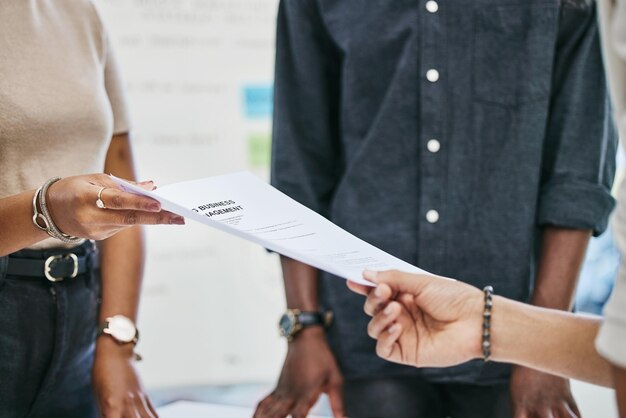 Please sign on the dotted line Shot of businesspeople transferring documents