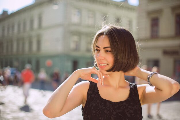 Pleased brunette model with bronze tan and natural makeup walking down the street. Space for text