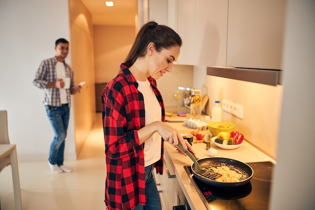 誘導コンロでオムレツを作って喜んでいる女性