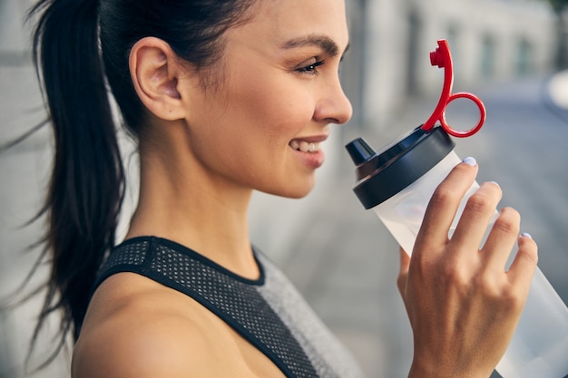 Pleased female person expressing positivity while enjoying her outdoors morning activity