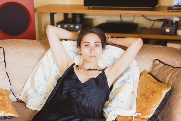 Photo pleased girl chilling on chair enjoying morning alone portrait of cute young woman