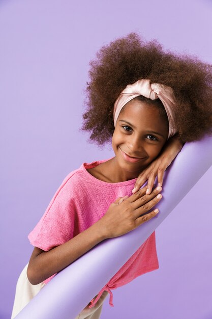 Pleased happy young pleased african girl kid posing isolated over purple wall
