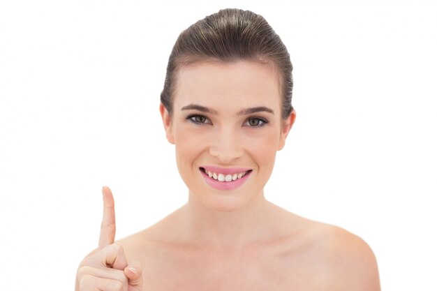 Photo pleased natural brown haired model raising her finger