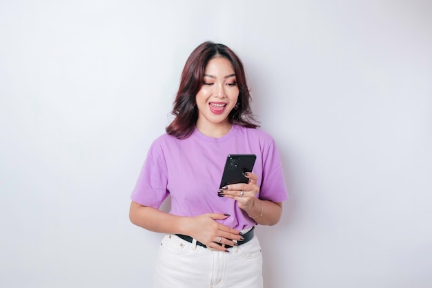 Pleased smiling Asian woman keeps hand on belly feels happy after ordering food by phone