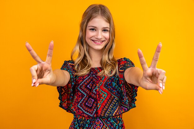 Pleased young blonde slavic girl gesturing victory sign 