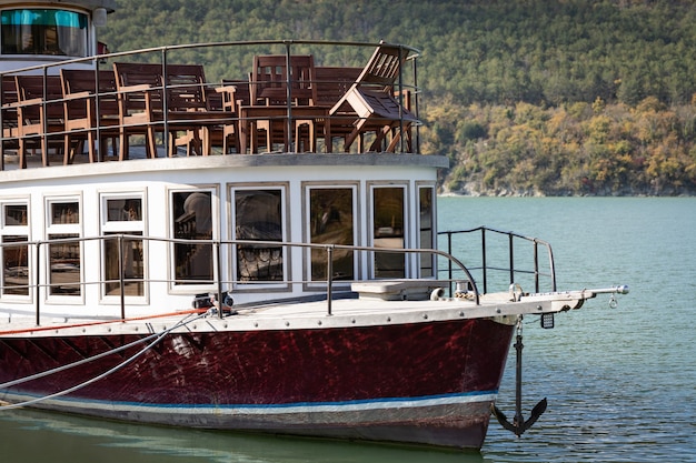 The pleasure boat is moored to the shore of the lake