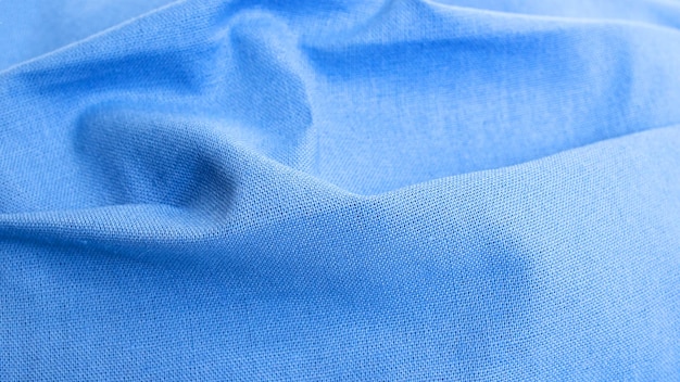 Pleats on blue cotton fabric close up