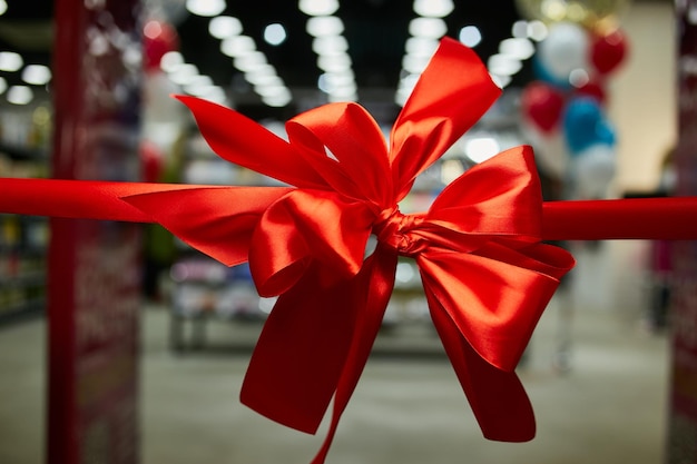 Plechtig rood lint met een strik bij de opening van een winkel-supermarkt-winkelcentrum