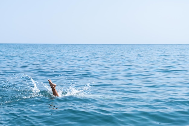 Plezier aan de kust, het kind springt in het water, duikt in het water van de oceaan. Spatten van water. strand spelletjes.