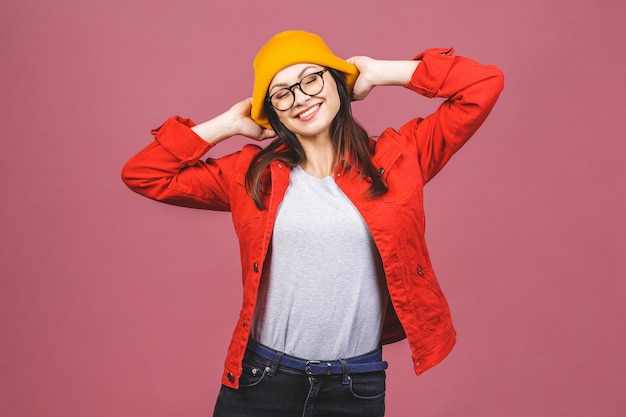 Plezier hebben! Portret van gelukkige jonge hipster vrouw in gele hoed en rood shirt