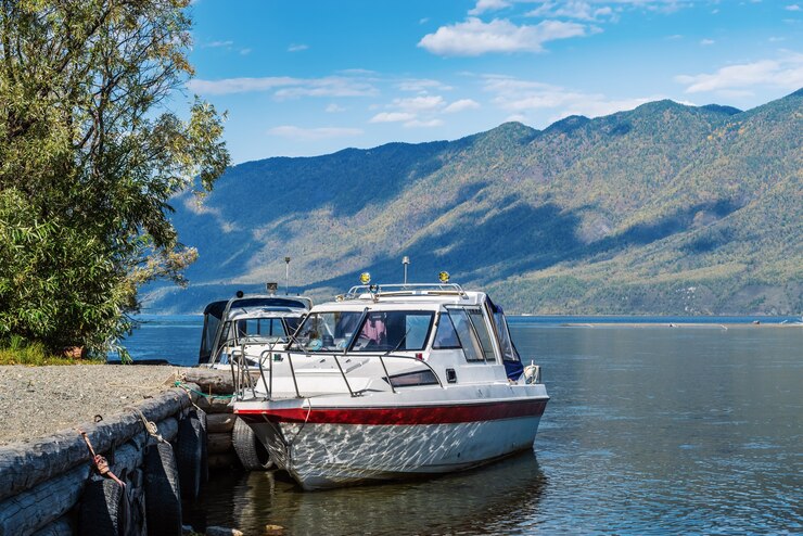 Pleziervaartuigen in de buurt van de pier aan de oever van het bergmeer Fall Russia Altai Lake Teletskoye