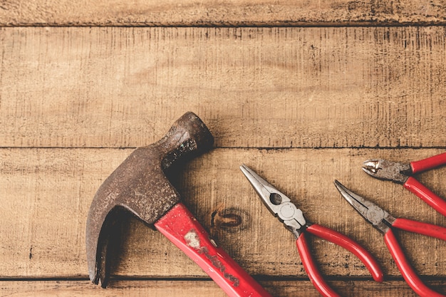 Pliers and hammer on wooden table. Copy space.