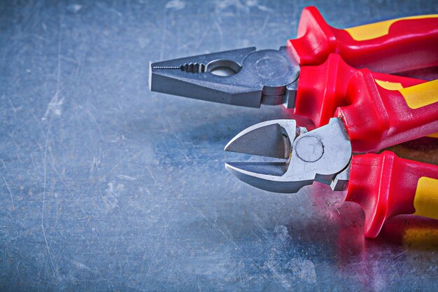 Pliers nippers on metallic background electricity concept