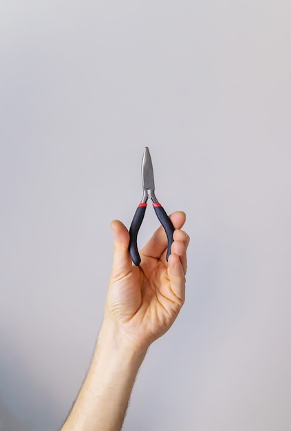 Pliers for repair in the hands of a male isolate. Selective focus. 