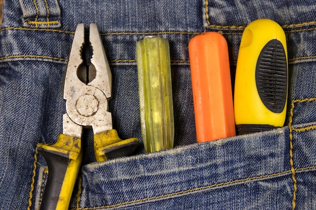 Photo pliers and screwdrivers in the jeans pocket