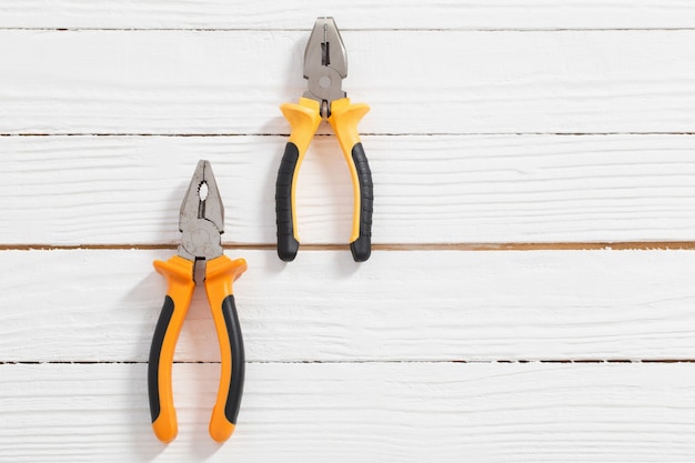 Pliers on white wooden surface