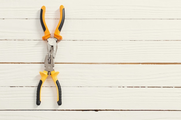 Pliers on white wooden surface