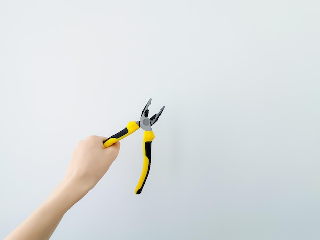 Foto pliers tagliatori di filo di colori vivaci su sfondo bianco isolato in mani femminili manicure femminile un