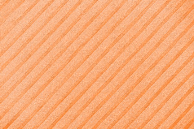 Plisse background toned in orange peel. geometric cloth lines. Fabric, textile close up.