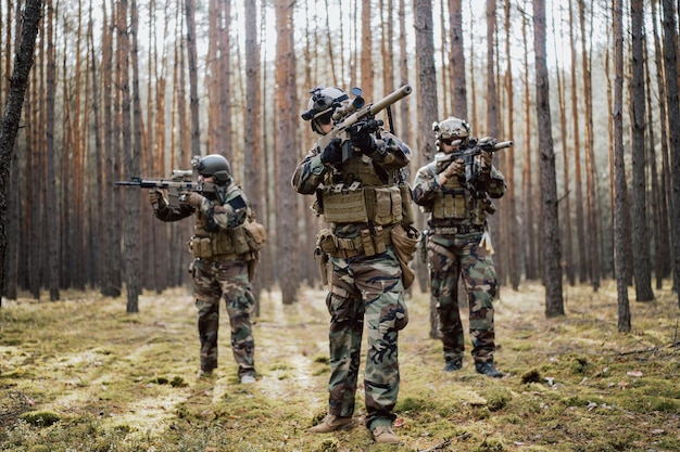 Ploeg van vier volledig uitgeruste soldaten in camouflage op een militaire verkenningsmissie gericht op