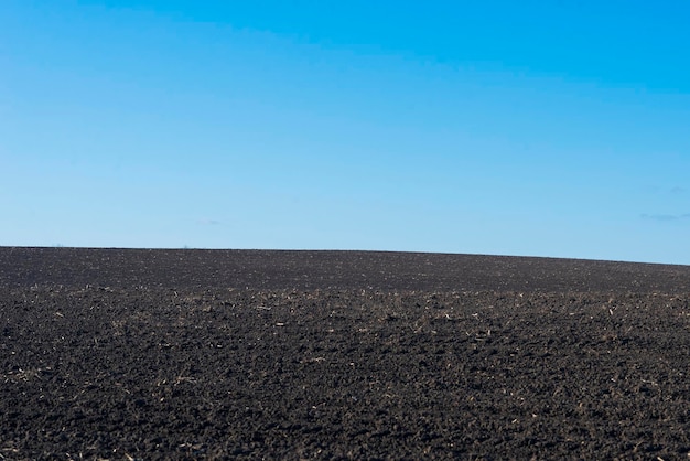 Ploughed field and blue sky as background