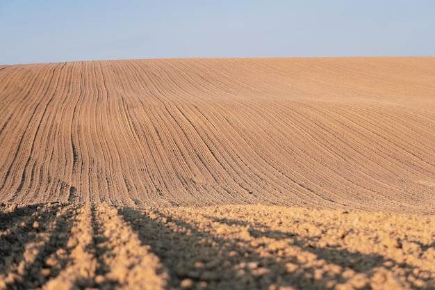 Ploughed field prepared for sowing. A plowed field with hills.