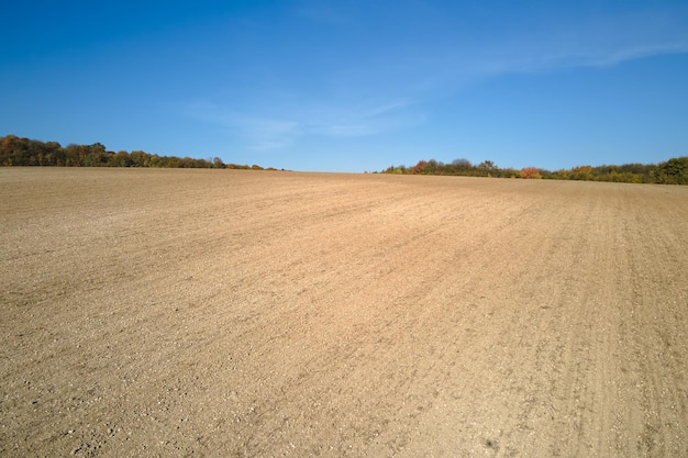 Фото Вспаханное сельскохозяйственное поле с возделываемой плодородной почвой, подготовленное для посадки сельскохозяйственных культур весной