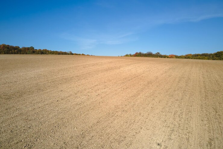 Photo plowed agricultural field with cultivated fertile soil prepared for planting crops in spring