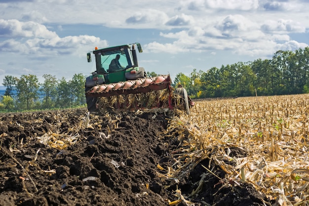 A plowed field after harvesting corn with a tractor complete with an eight-body plow
