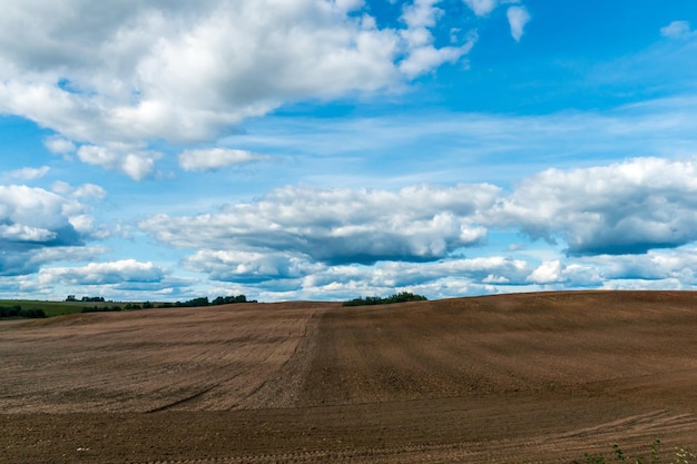 空を背景に耕された畑麦畑に作物を植える季節田園地帯に菜種麦ライ麦と大麦を植えるための畑を準備する