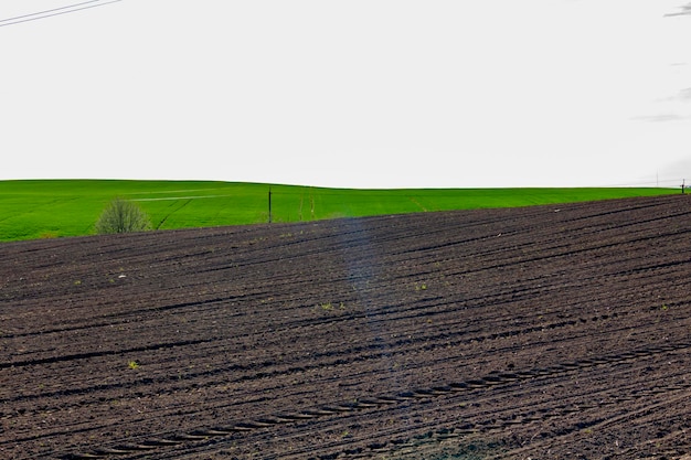 Вспаханное поле для посадки сельскохозяйственных культур на фоне голубого неба