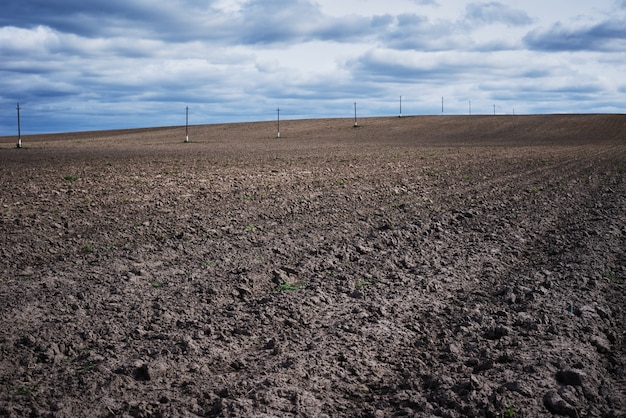 Plowed field in spring day. Plowed soil for planting crops