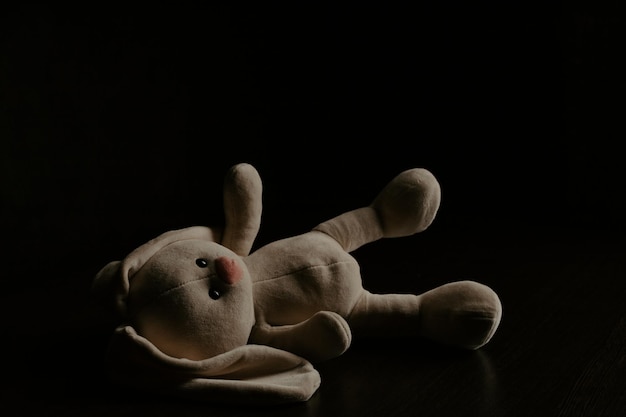 Pluche konijntje ligt alleen in het donker Lonely concept internationale vermiste kinderdag