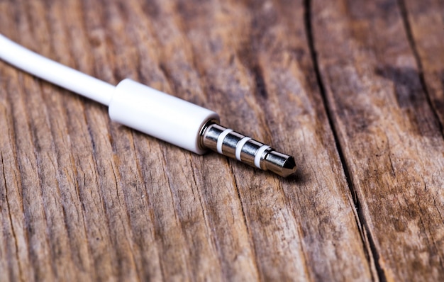 Plug headphones on wooden background