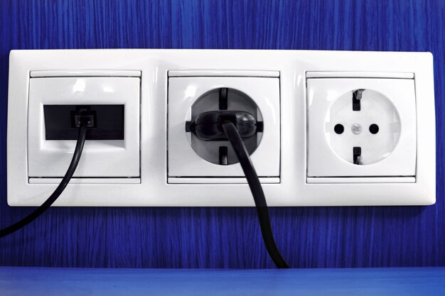 Plugs in electric and phone  socket.