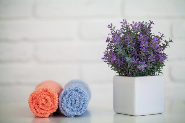 Pluizige badhanddoeken op lichte houten tafel met decor