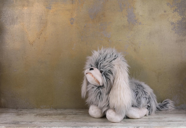 Foto pluizige speelgoedhond op houten vloer
