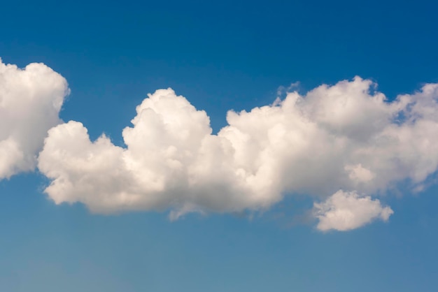 Pluizige witte wolken op een blauwe hemelachtergrond