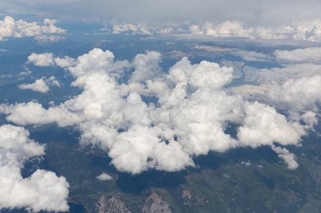 Pluizige witte wolken, uitzicht vanuit vliegtuigraam