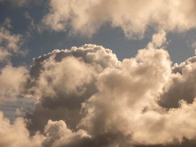 Foto pluizige wolken boven zonsondergang hemel pluizige cumulus wolk vorm foto sombere cloudscape achtergrond rook in de lucht