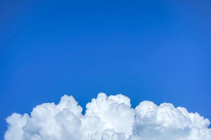 Pluizige wolken over blauwe hemelachtergrond