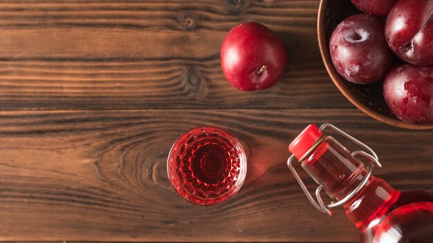 Plum alcoholische drank en pruimen bessen op de bruine tafel