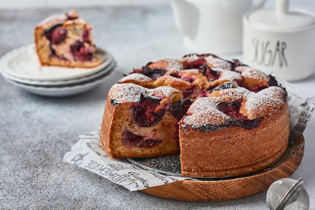 Plum cake rustic homemade on light stone background. Selective focus.