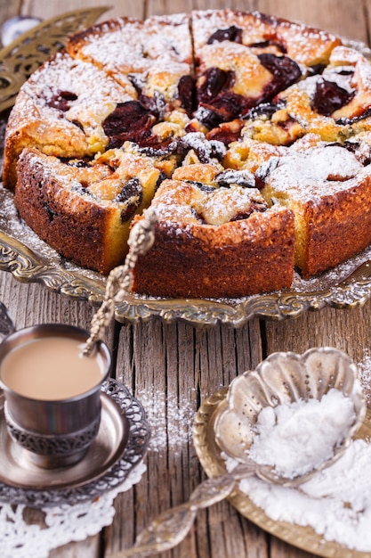 Plum cake with powdered sugar and a Cup of coffee