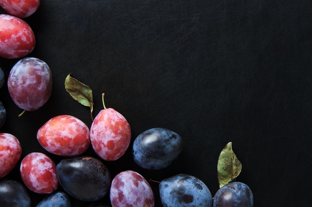 Frutti di prugna sul tavolo nero