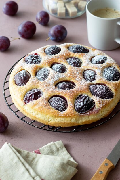 Plum pie on a pink background. Baking. Vegetarian food.