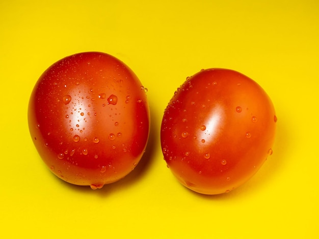 Plum tomato on a yellow background Red vegetable on the table fresh vegetables