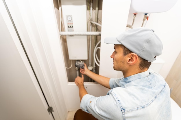 Plumber Adjusting Temperature Of Electric Boiler.