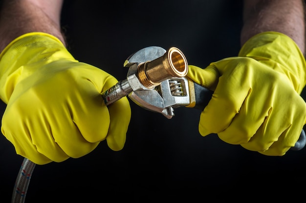 A plumber connects a high pressure hose when repairing equipment