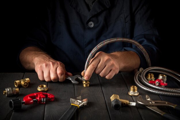 Plumber connects the high pressure hose with a wrench to the brass fittings